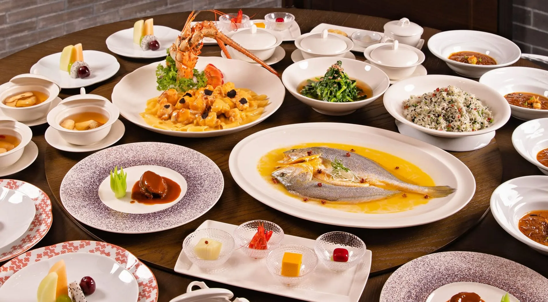 Mesa de banquete montada con la vajilla y los platos del menú servidos al centro