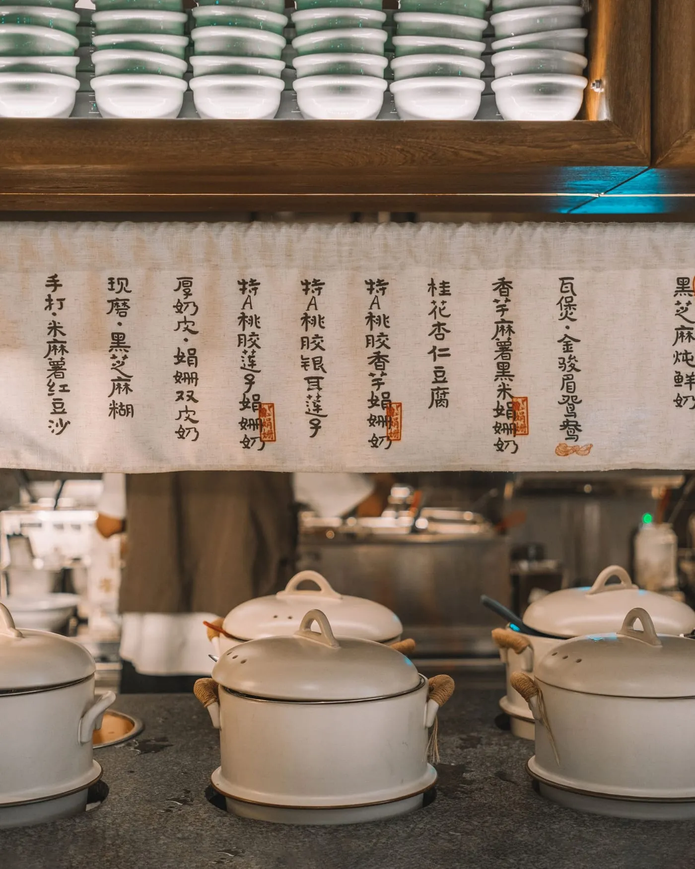 Ollas de cerámica en la cocina, bajo los carteles de la carta