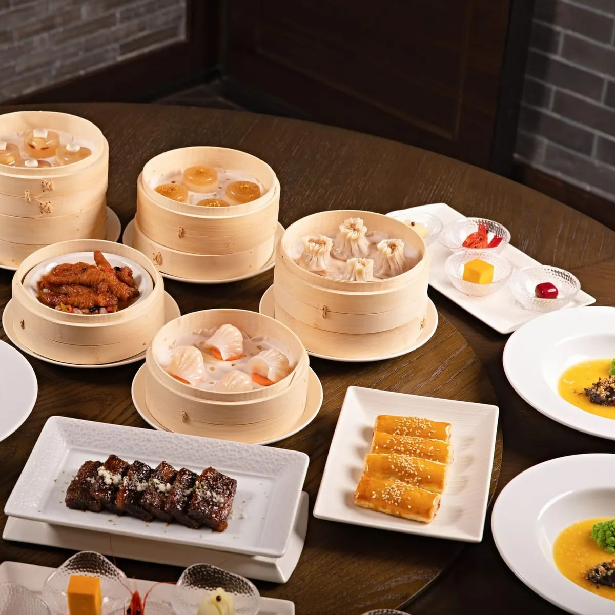 Surtido de dim sum al vapor servido en canastas de bambú sobre mesa de banquete