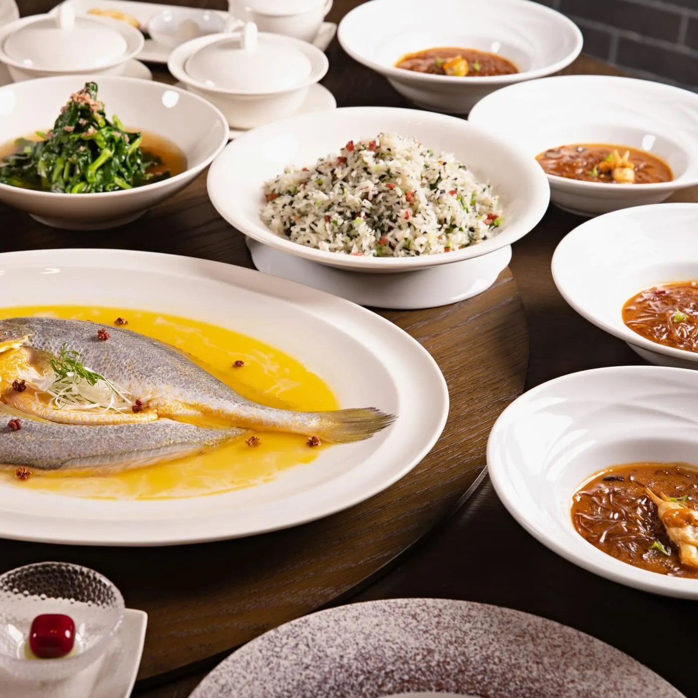 Mesa de banquete con pescado entero y platos de mariscos servidos
