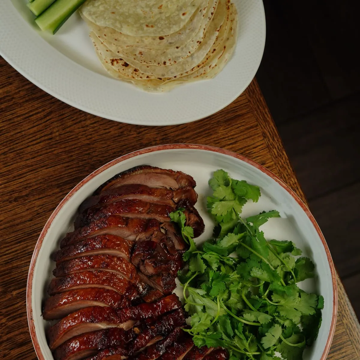 Pato laqueado en láminas con cilantro y panqueques al lado