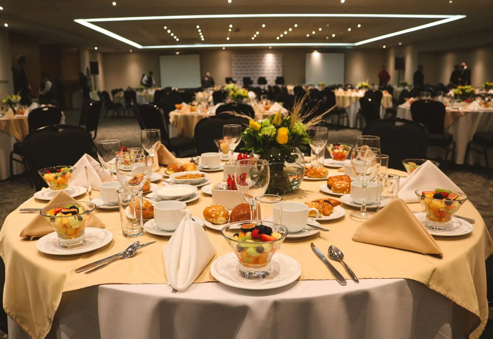 Salón principal montado para un evento, con varias mesas redondas vestidas