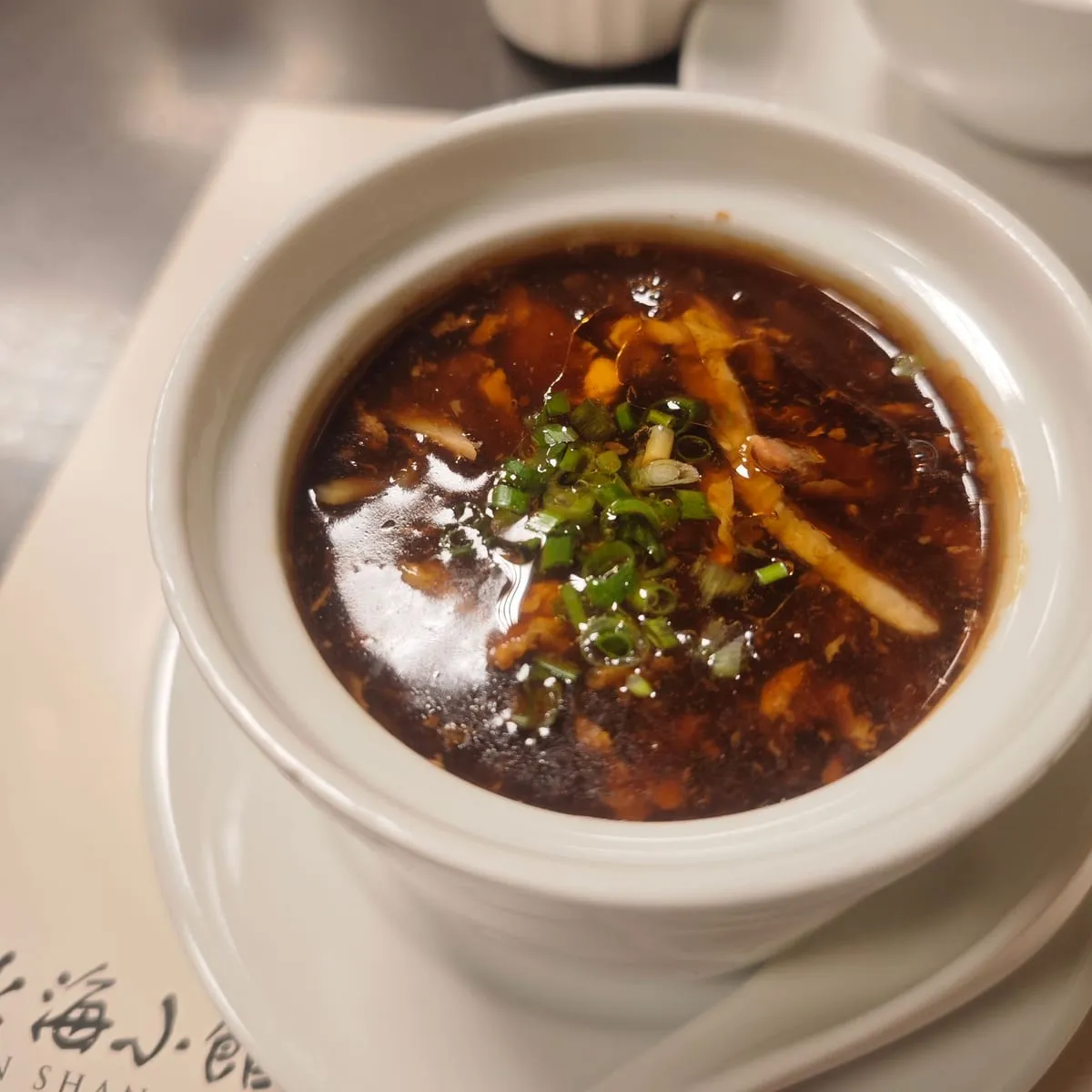 Sopa espesa servida en tazón blanco con guarnición encima